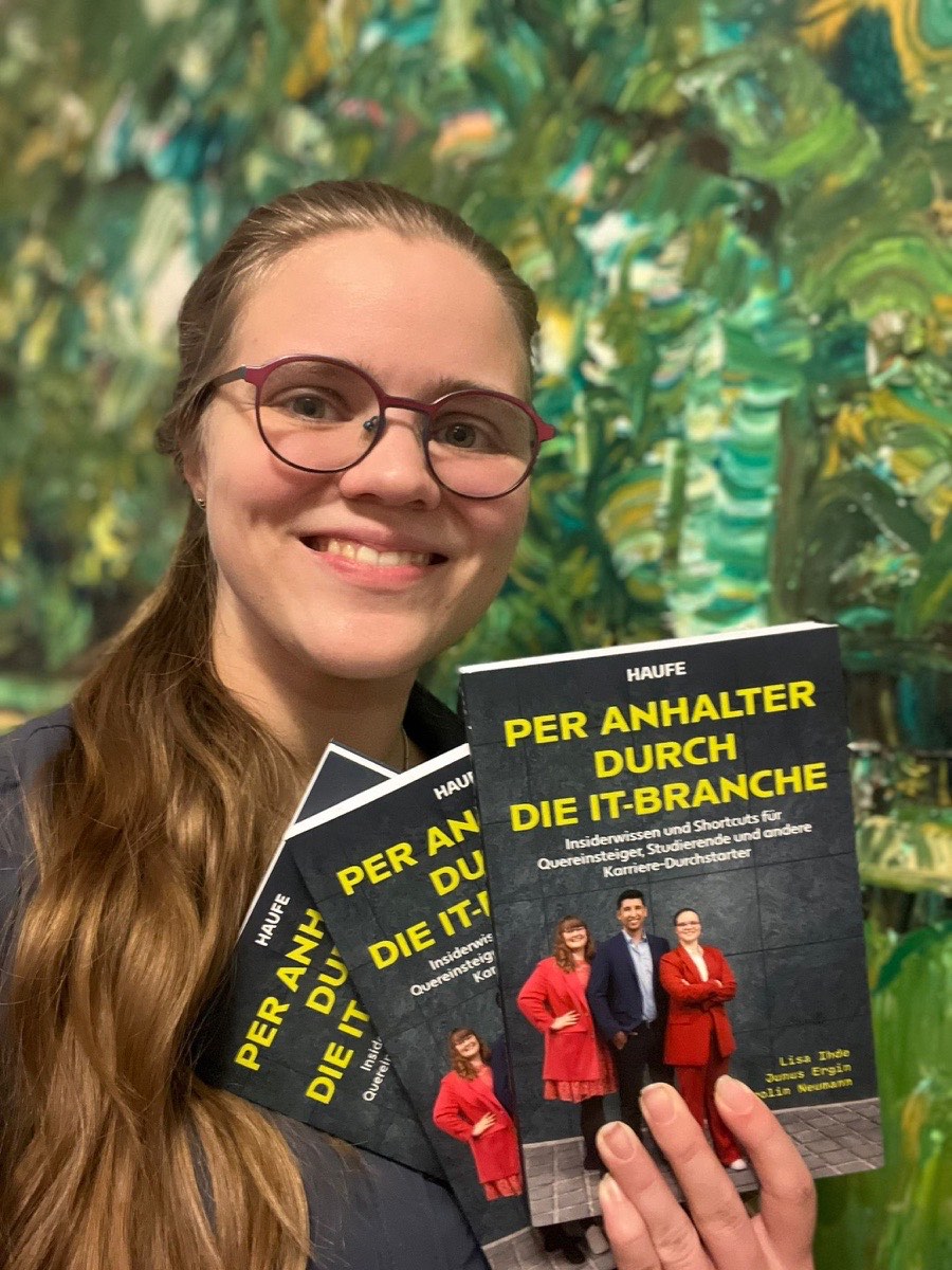 Carolin Neumann holding copies of the book Per Anhalter durch die IT-Branche