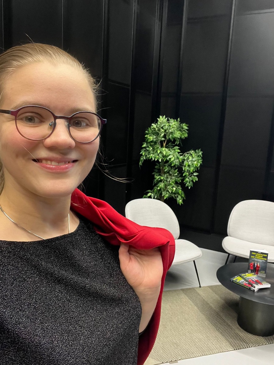 Carolin Neumann smiling, red blazer over her shoulder